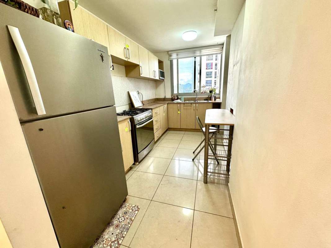 Galley kitchen with window, modern appliances, light wood cabinets in PH Rokas Condado del Rey Panama