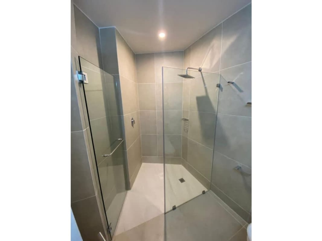 Minimalist bathroom with walk-in shower and rainfall showerhead in PH Oceana Santa Maria Panama