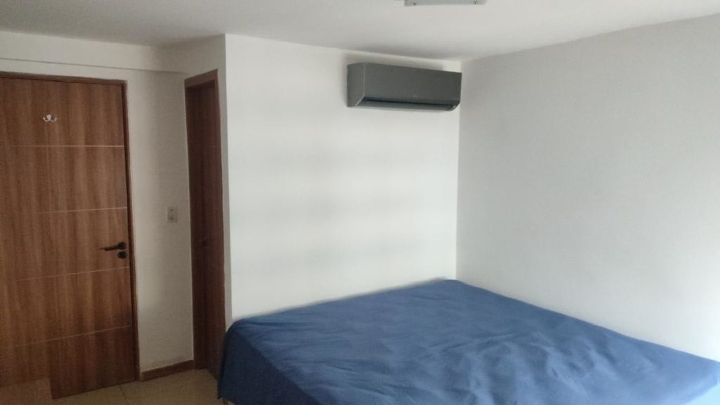 Bedroom featuring AC unit, blue bedding, wood door PH Terrazas del Rey Condado del Rey Panama