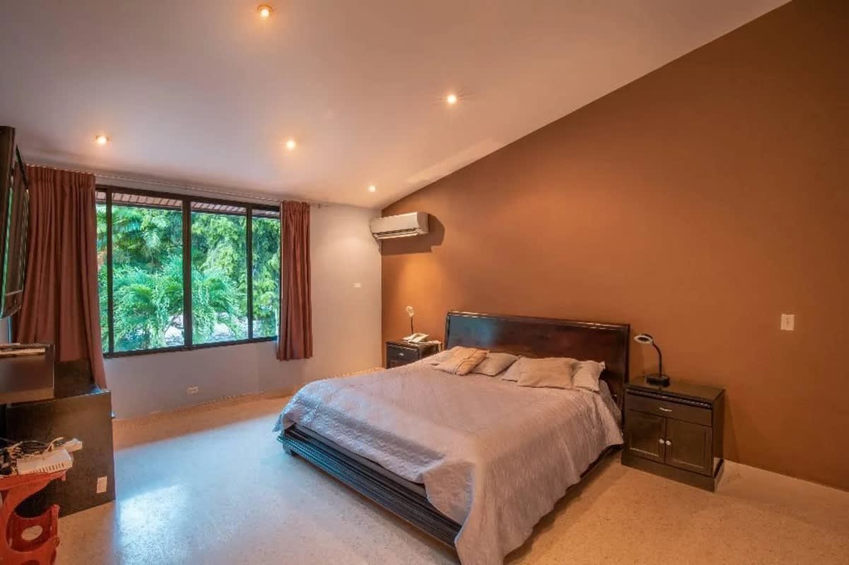 Bedroom with blue accent wall, natural light and minimalist decor in duplex house Obarrio Panama City