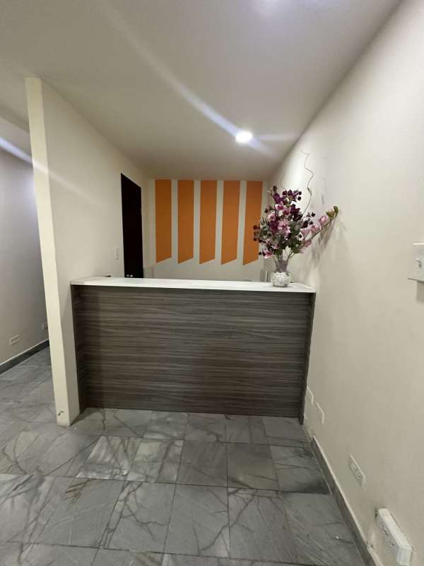 Lobby with wooden reception desk marble floor orange decor in Torre BAC Panama City