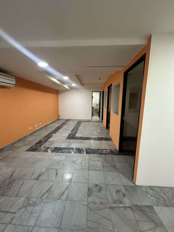 Partitioned offices with glass walls marble tiles and accent colors inside PH BAC Tower Avenida Balboa Panama