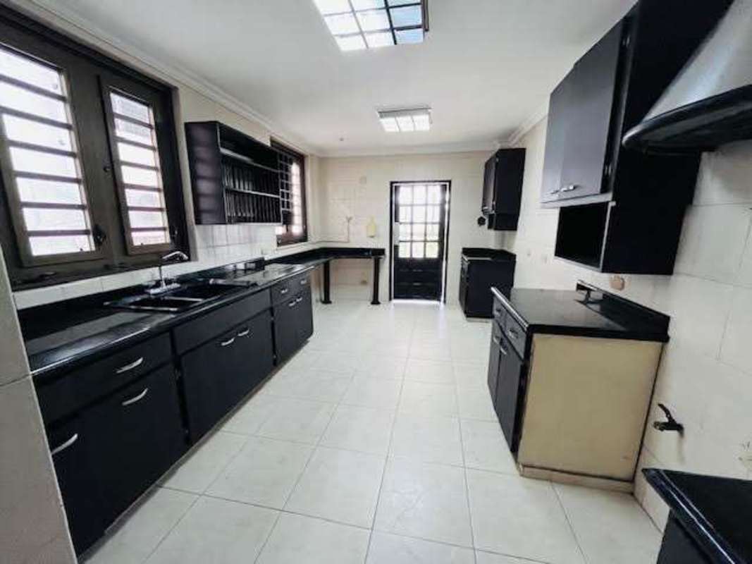 Black cabinetry, granite countertops, tile floors kitchen La Alameda duplex home Panama