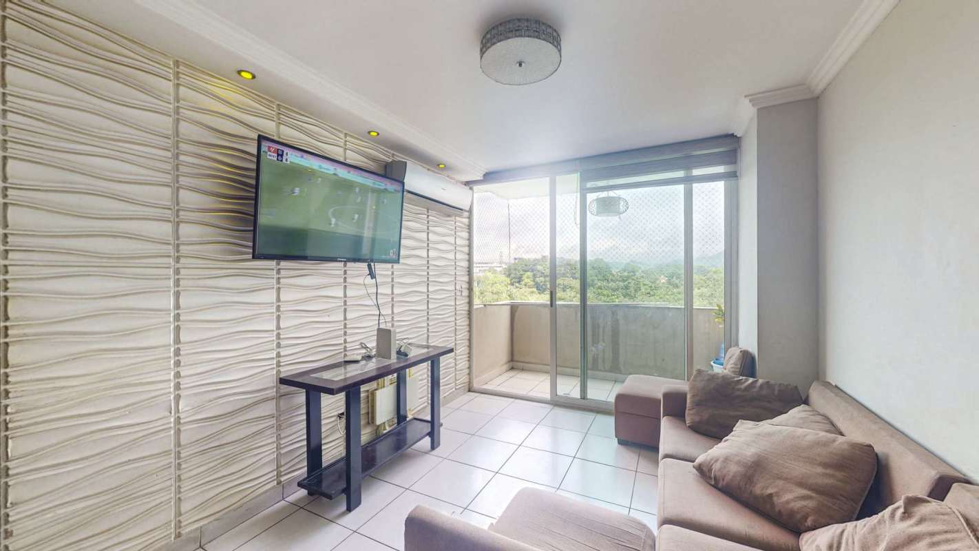 Modern living room with accent wall, mounted TV and balcony in PH Green Park Condado del Rey Panama