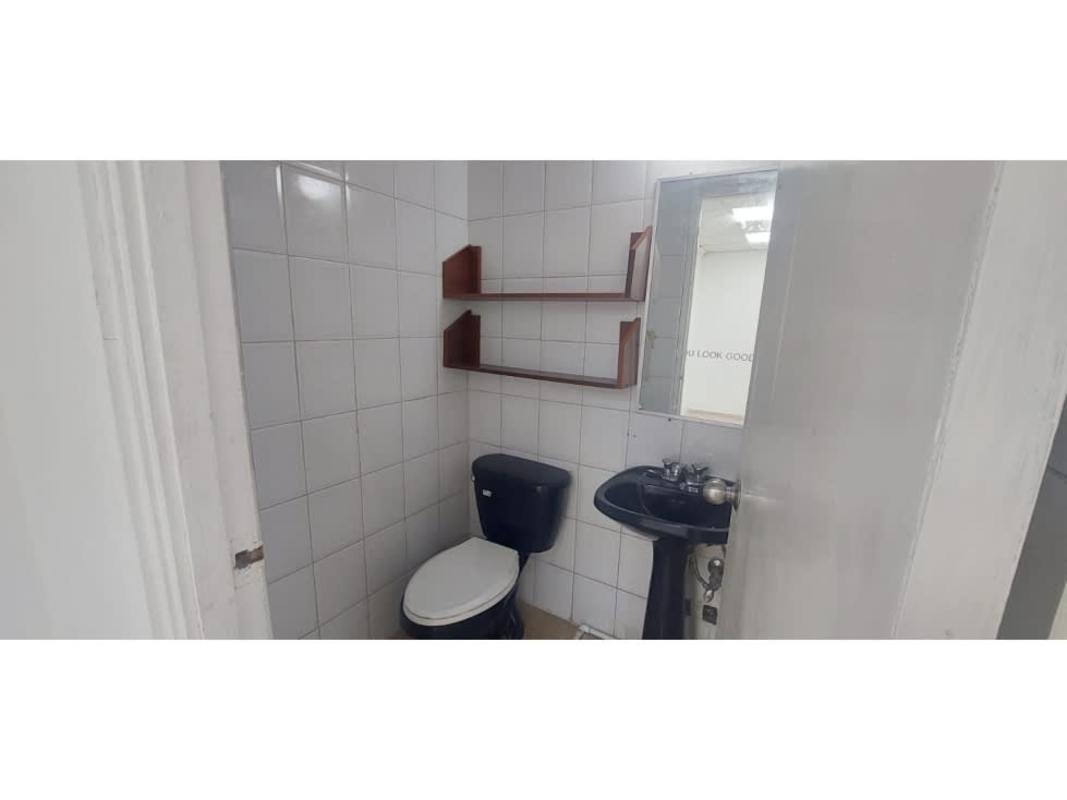 Minimalist bathroom with tile walls sink and toilet inside commercial space Plaza San Fernando