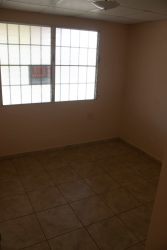 Empty bedroom with large window and tiled flooring in Panama house