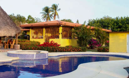 Traditional rustic kitchen with green tile backsplash and wooden cabinets in Penonome estate