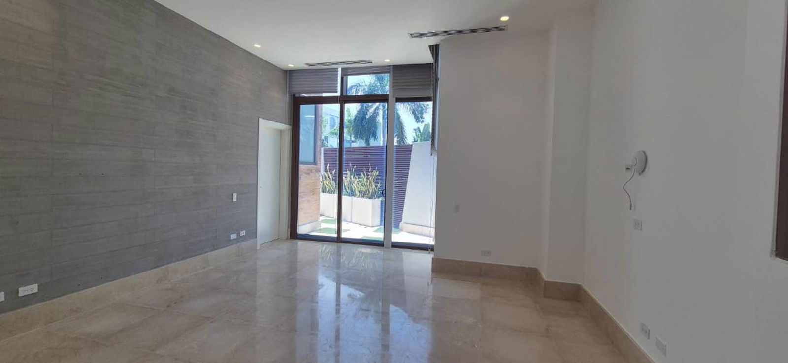 Modern living room with glass doors opening to patio garden Ocean Reef Panama.