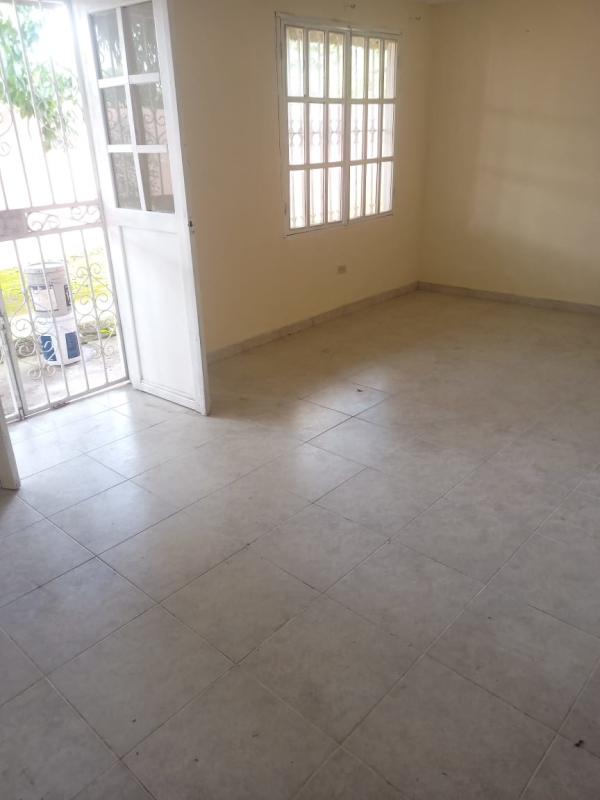 Spacious living room with tiled floor, large window, glass door to backyard Las Cumbres Panama