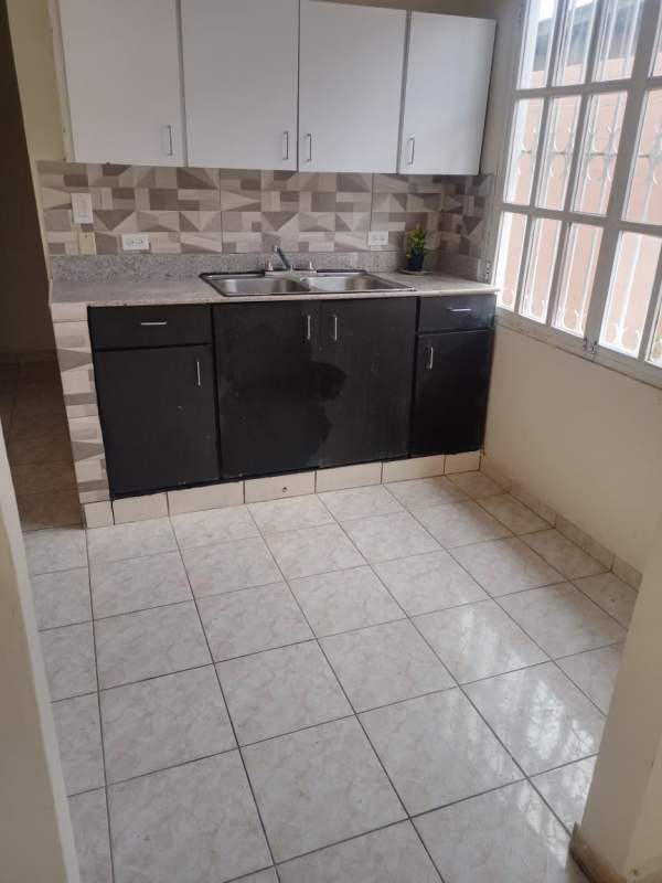 Modern kitchen with geometric backsplash, double sink, cabinets in Las Cumbres house Panama