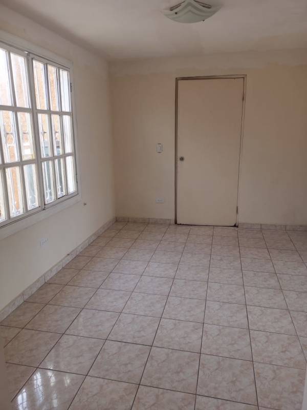Empty room with tiled floor and large window in Las Cumbres Panama house for sale