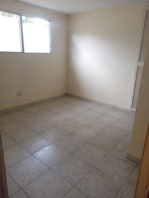 Empty bedroom with tiled floor, closet with louvered doors, window in Las Cumbres house Panama for sale