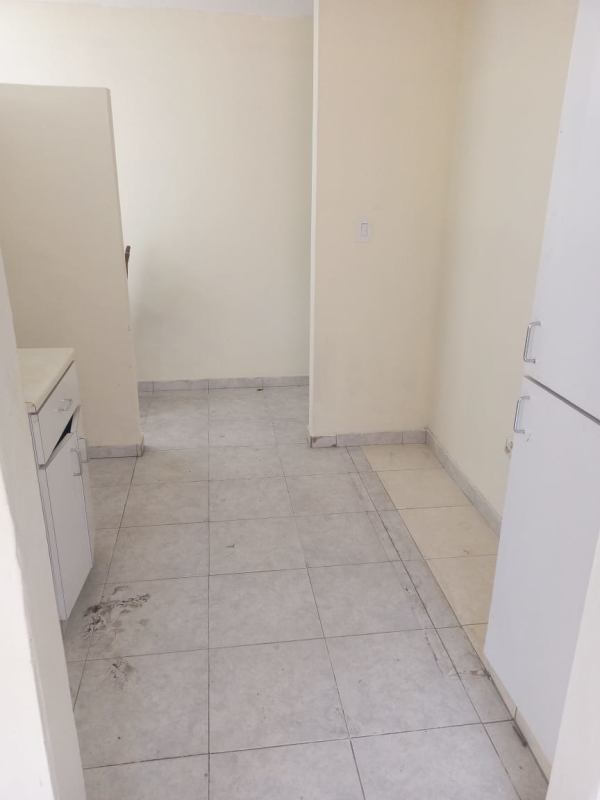 Simple minimalist kitchen with white tile, cabinets, double sink in Las Cumbres house for sale Panama