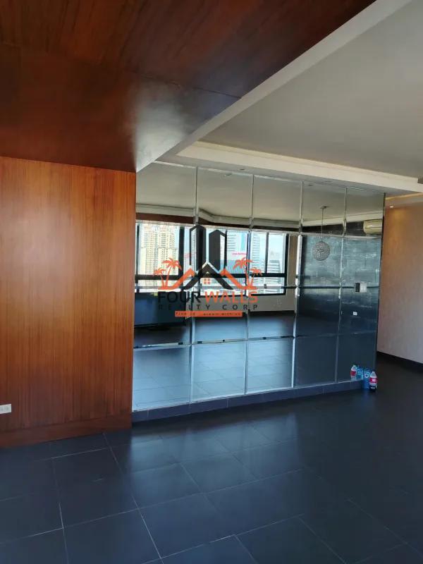 Spacious living room with wood panel accent, panoramic windows at PH Pacific Coast Panama