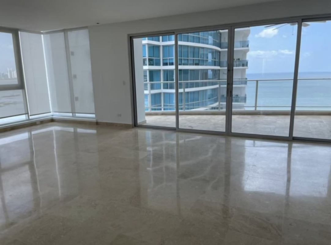 Bright spacious living room with large glass doors opening to balcony overlooking Pacific Ocean in Pacific Village Punta Pacifica