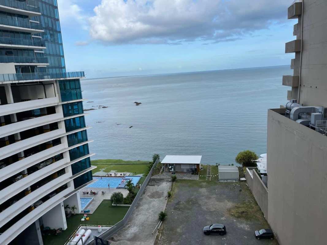 High-rise towers Pacific Village overlooking ocean, pool deck and green lawn Punta Pacifica Panama