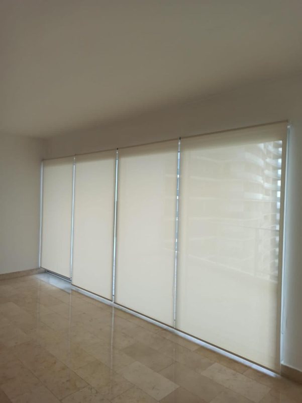 Modern empty living room with marble floors and blinds covering full-height windows in Pacific Village Punta Pacifica