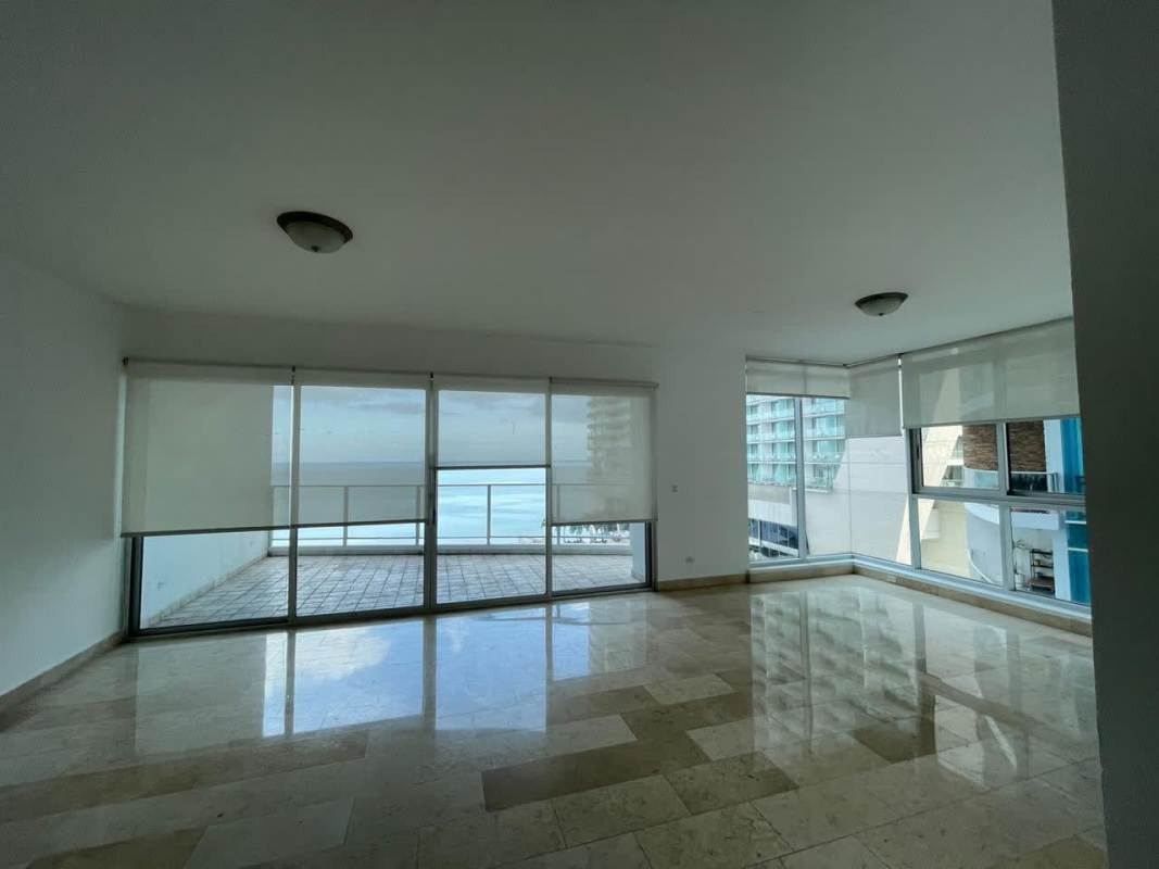 Spacious modern living room with blinds and large windows with ocean and city views Pacific Village Punta Pacifica