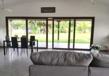 Open-plan living and dining space with sliding doors to patio at Pedasí villa