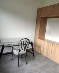 Bright dedicated home office room with built-in cabinetry, large mirror and glass desk in Pedasí home