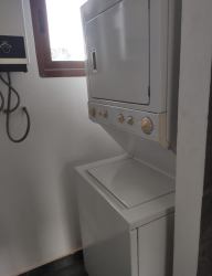 Compact laundry space with stacked washer dryer and window Pedasí Panama villa