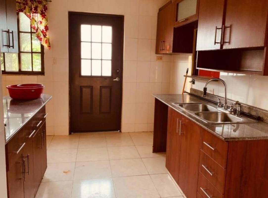 Spacious empty bedroom with tiled floor and window view to garden Mirador del Lago Panama