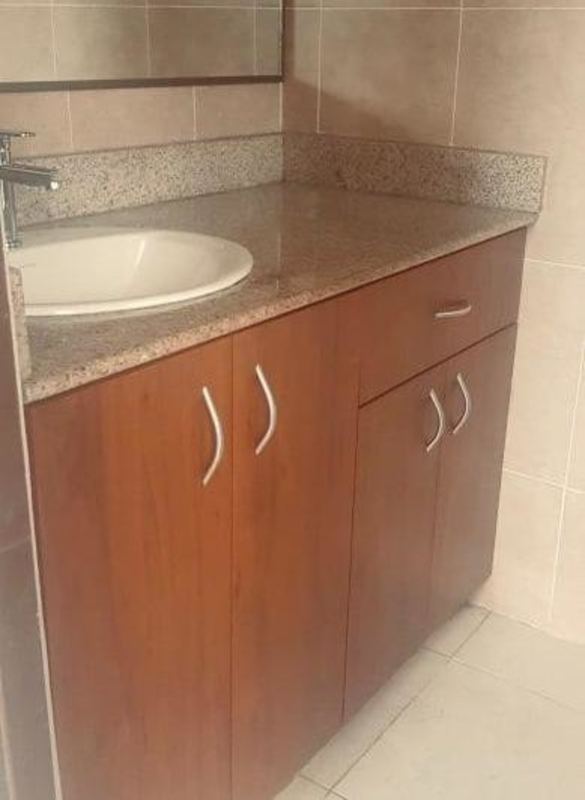 Kitchen interior with granite counters, wooden cabinetry and double sink in Mirador del Lago house