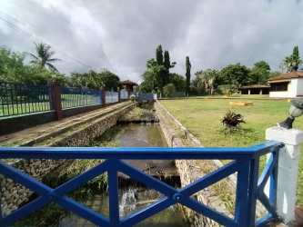 Tropical fenced garden with stone-lined water canal and lush landscaping country villa Bugaba Chiriquí Panama