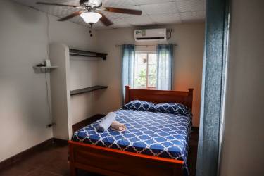 Open-plan dining and living room with ceramic tile floors and large windows in Pedasi house