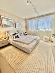 Modern living room with double-height windows, curved sofa, abundant natural light in PH Imaterra House Panama Pacifico