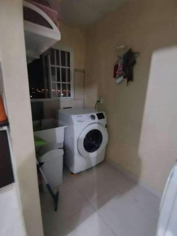 Small laundry area with washer and utility shelving inside apartment in Las Acacias Panama