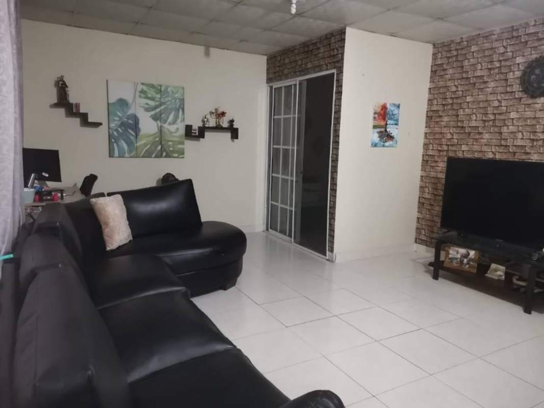 Bright living room with sliding glass door to balcony brick accent wall Las Acacias Panama City