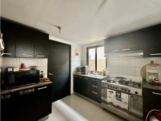 Kitchen with dark cabinets, stove and microwave Woodlands Panama Pacifico
