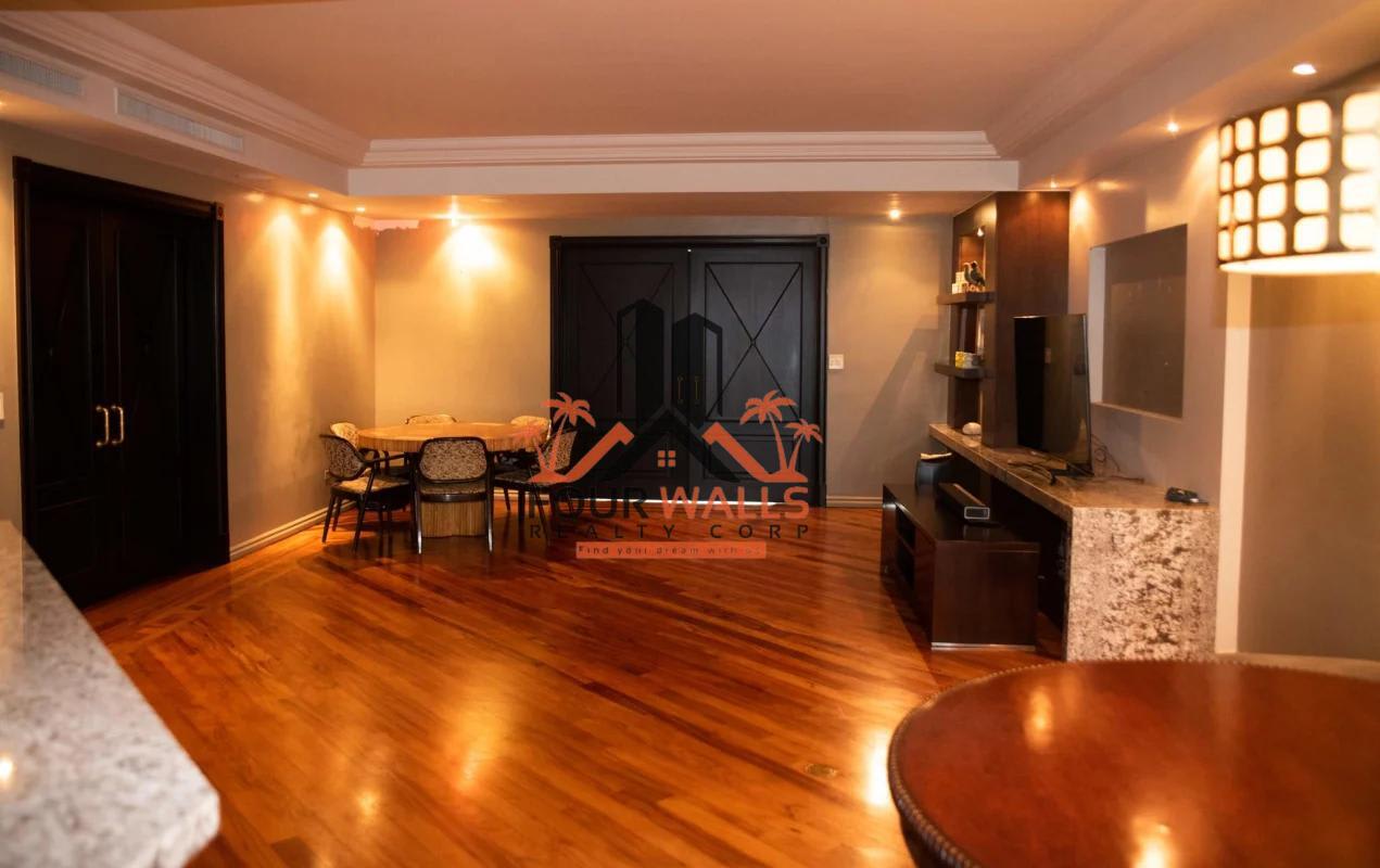 Contemporary open-plan living and dining room with wood floors, recessed lighting in PH Panamar penthouse Coco del Mar