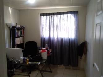 Small home office space with natural light and tile floor in remodeled Arboleda house Panama Oeste