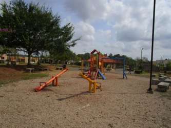 Colorful children's playground with benches and trees in PH Los Olivos Arboleda Panama Oeste