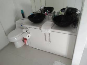 Modern bathroom with double black sinks and white cabinetry in house Panama Oeste