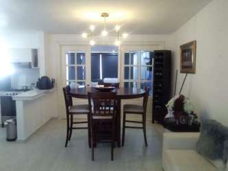 Modern dining room with contemporary light fixture close to kitchen in Panama Oeste house