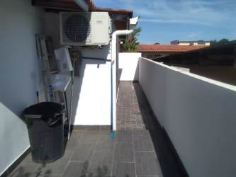 Small outdoor balcony space with AC unit and black trash bin at PH Los Olivos Arboleda Panama Oeste