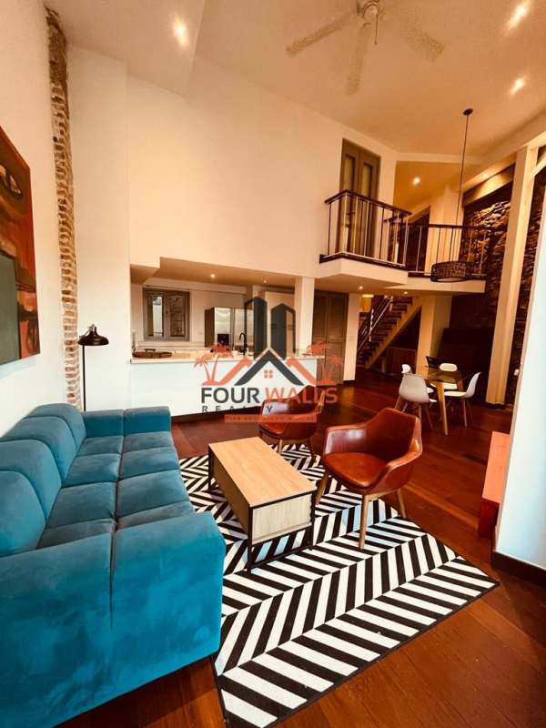 Modern living room with floor-to-ceiling windows, high ceiling, blue sofa and wood floors at PH Jeronimo, Casco Viejo