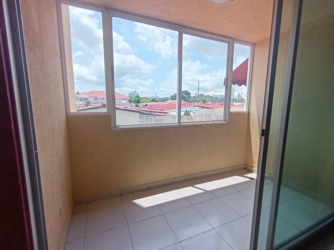 Enclosed balcony with large windows and tile flooring view to rooftops PH Mikonos Panama