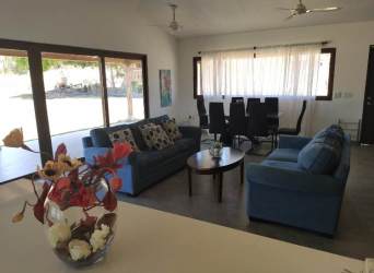 Open living dining blue sofas sliding doors garden view Pedasi villa Panama
