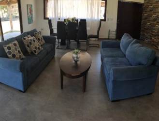 Living with blue sofas dining area stone wall open layout Pedasi villa Panama