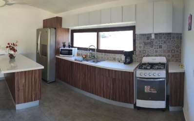 Kitchen with wood cabinetry patterned backsplash natural light Pedasi villa Panama