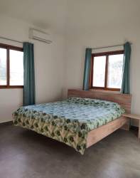Bright minimalist bedroom with AC, windows and neutral palette in Pedasí Oasis Residences Panama