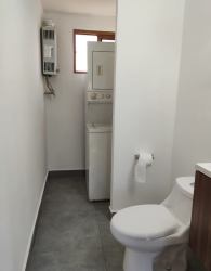 Compact bathroom with washer dryer and natural light window Pedasí Oasis Panama