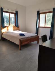 Bedroom with natural light, minimalist decor, AC unit in Pedasí Oasis Panama