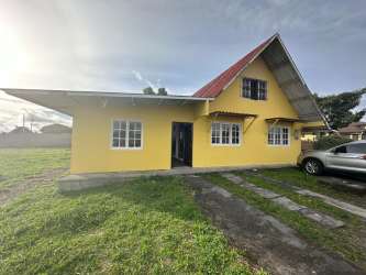 Yellow house A-frame red roof corner lot driveway yard Volcán Chiriquí Panama