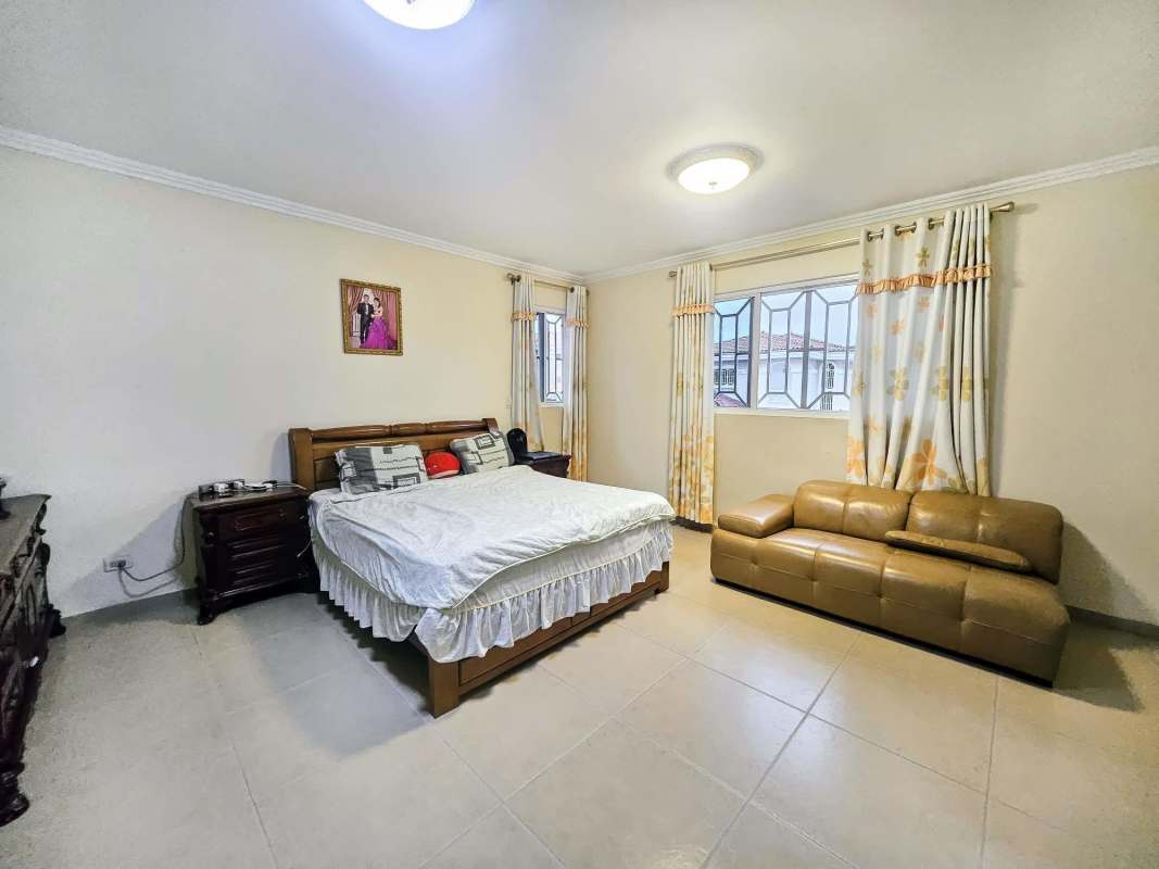 Covered community social area with seating and fans overlooking garden and pool