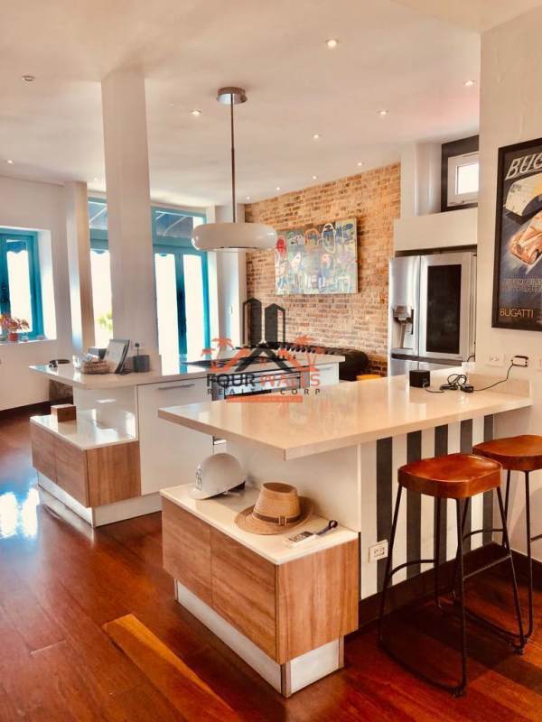 Kitchen with island, exposed brick, wood floors PH Jerónimo Casco Viejo
